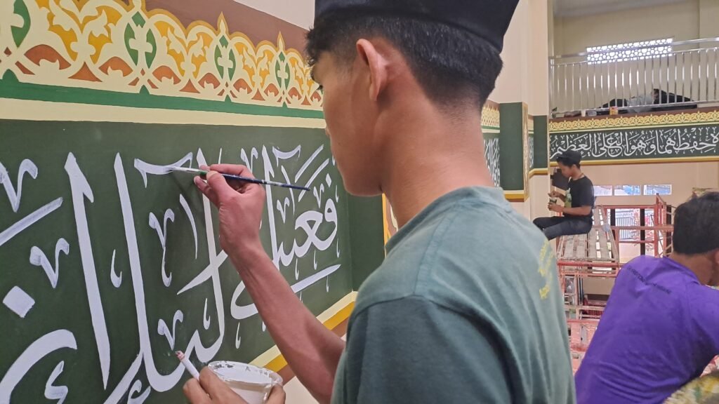 Kaligrafi yang dilukis pada dinding masjid secara manual