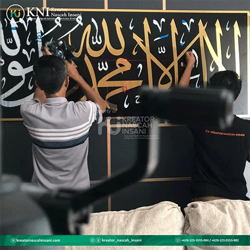 Pekerja sedang melakukan finishing kaligrafi syahadat bergaya minimalis pada panel dinding masjid